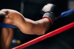Sports, fight and hand of a boxing man resting in the corner of a boxing ring during an exhibition
